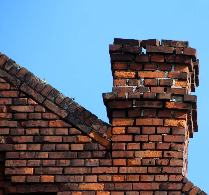 Damaged chimney on an Cohasset home showing cracks and missing mortar